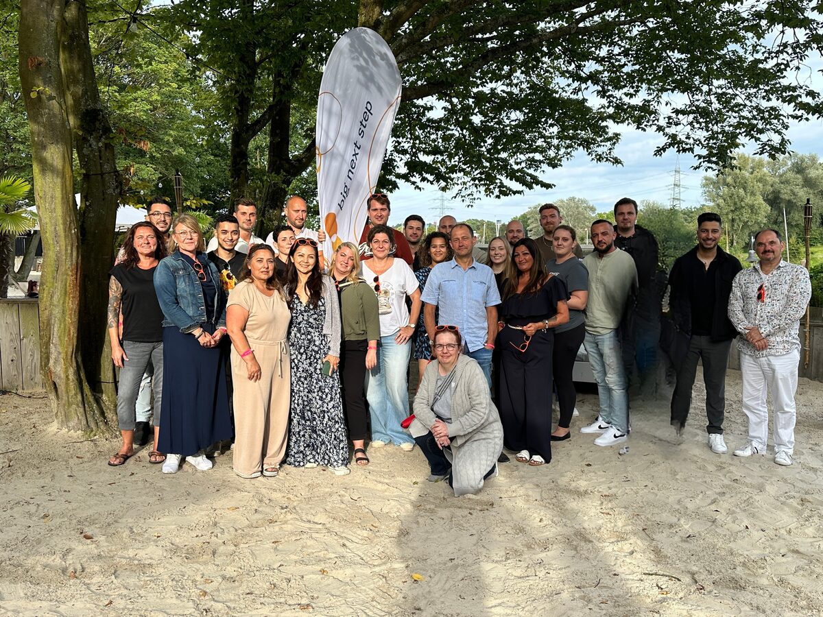 Das Team von big next step beim Sommerfest vor dem Firmenbanner